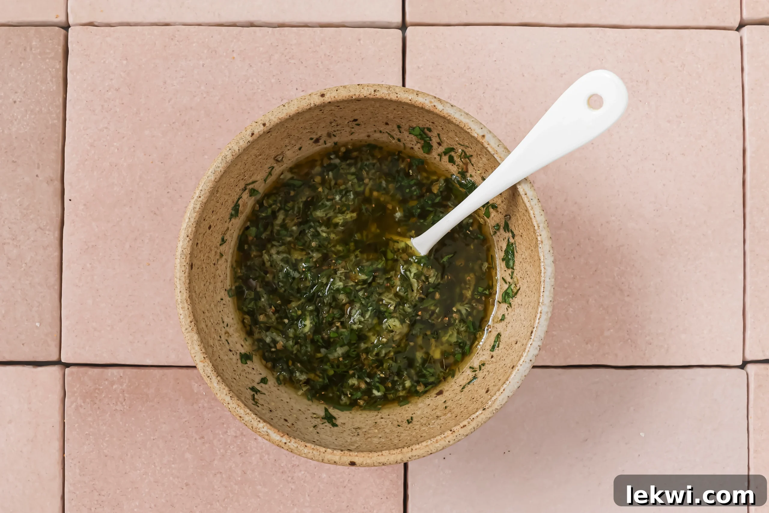 Chicken souvlaki marinade in a bowl, with fresh herbs.