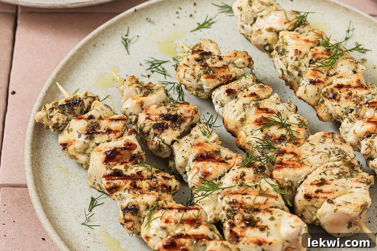 Cooked chicken souvlaki skewers arranged neatly on a plate.