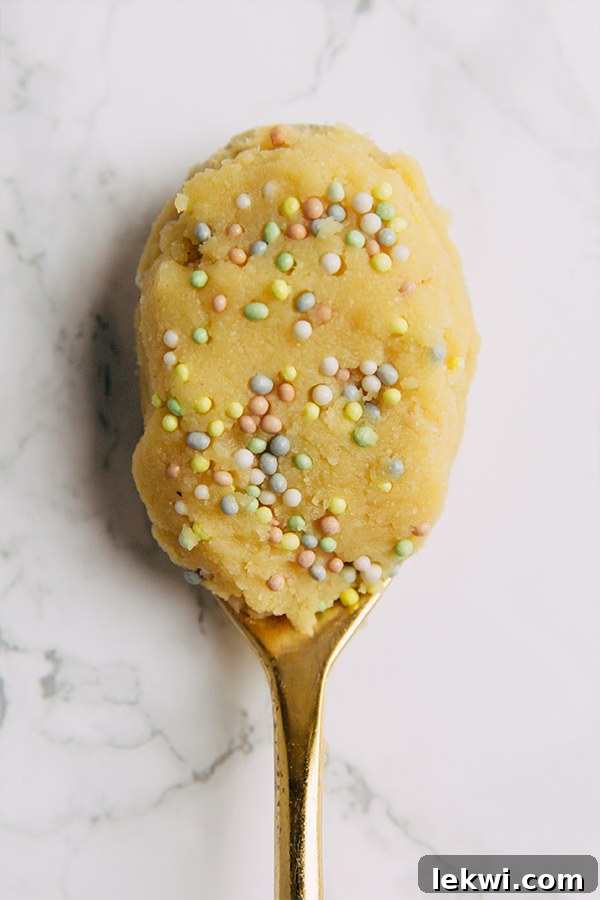A close-up shot of a bowl of gluten-free edible cake batter, rich in texture and color, ready for a delicious no-bake treat.