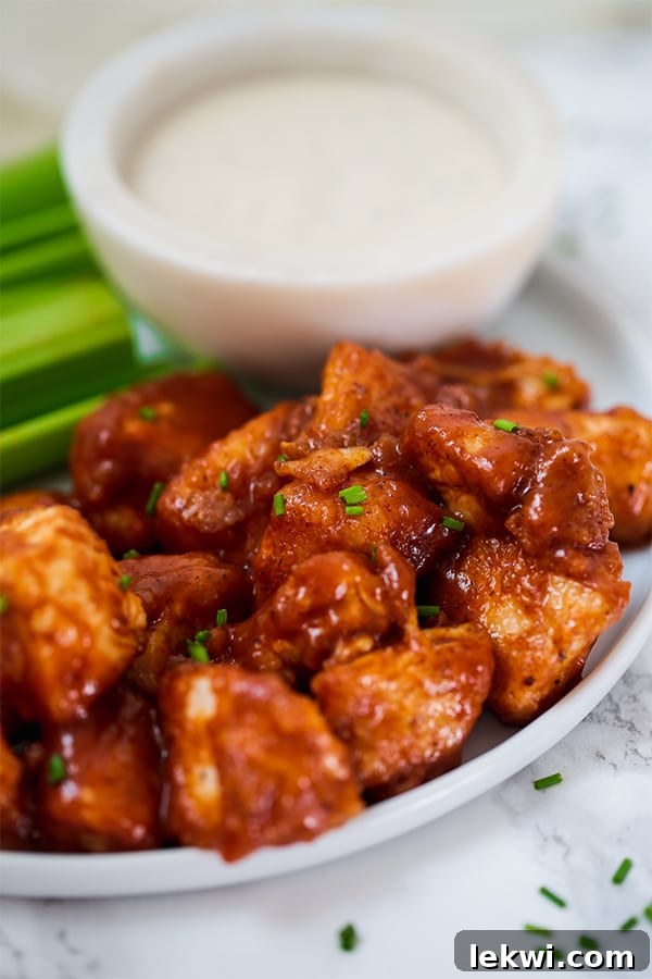 A plate with bbq chicken poppers on it next to dipping sauce.