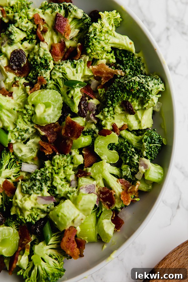 A white bowl filled with broccoli salad.