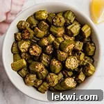 A white bowl filled with oven roasted okra.