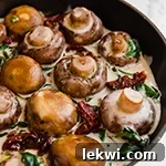 A cast iron skillet filled with creamy Tuscan mushrooms.