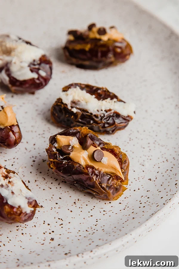 A white plate filled with almond butter and coconut butter stuffed dates.