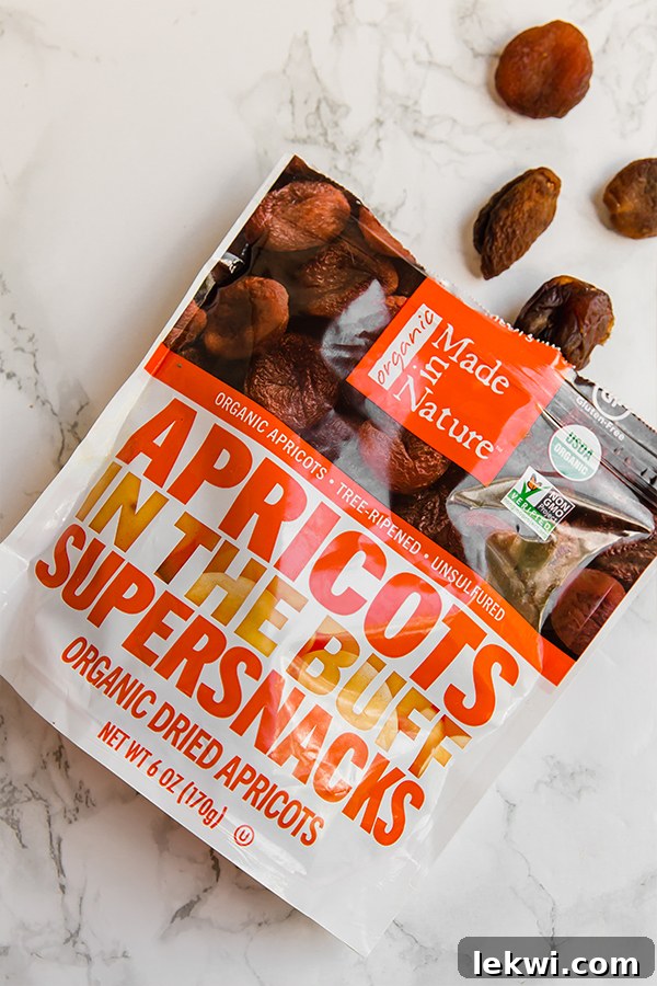 A bag of dried apricots out on a counter with a few apricots spilling out.