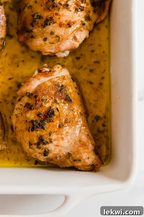 A white baking sheet with balsamic ranch chicken thighs after baking.