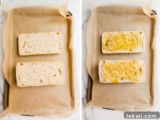 A baking sheet covered in parchment paper with slices of sourdough before and after adding garlic spread to it.