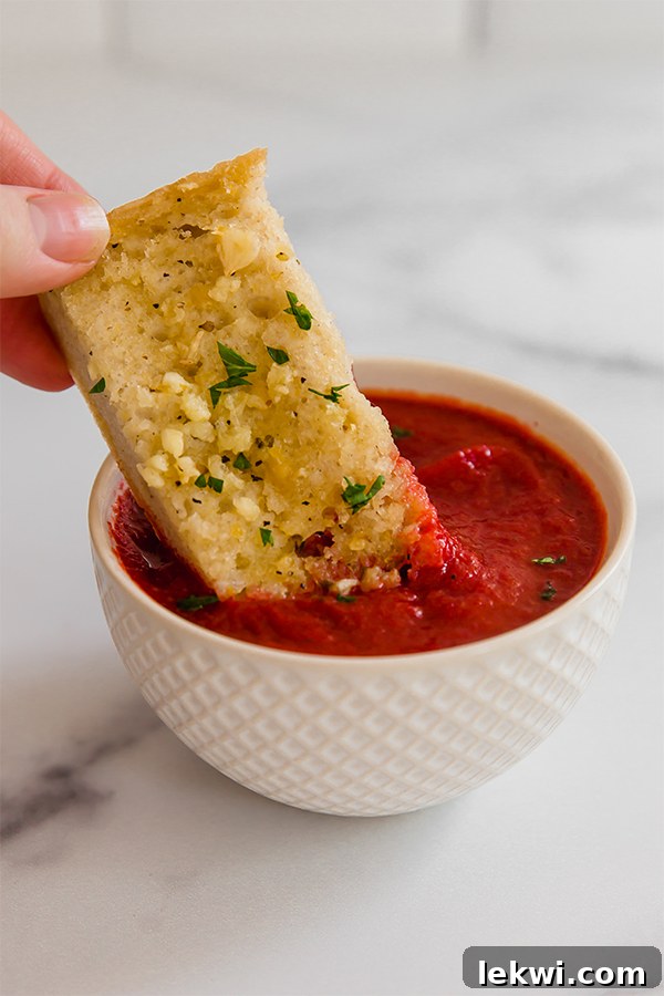 Garlic bread dipping in sauce