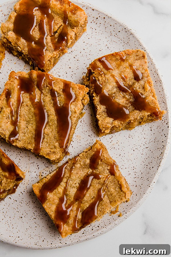 Perfectly baked paleo salted caramel pumpkin blondies, drizzled with luscious caramel, ready to be enjoyed as a fall dessert.