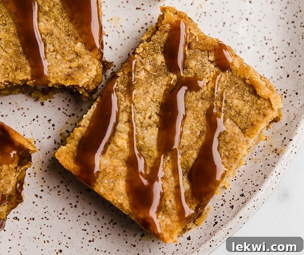 A close-up of a single paleo salted caramel pumpkin blondie, showcasing its rich texture and generous caramel topping.