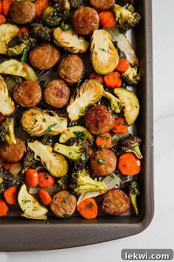 Crispy roasted sausage and colorful vegetables on a sheet pan, ready to serve.
