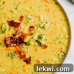 A white bowl filled with broccoli cheese soup.