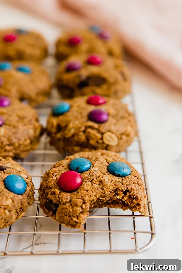 Freshly baked gluten-free monster cookies cooling on a wire rack, ready to be enjoyed.