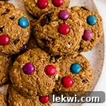 A white plate filled with gluten free monster cookies, ready to be served.