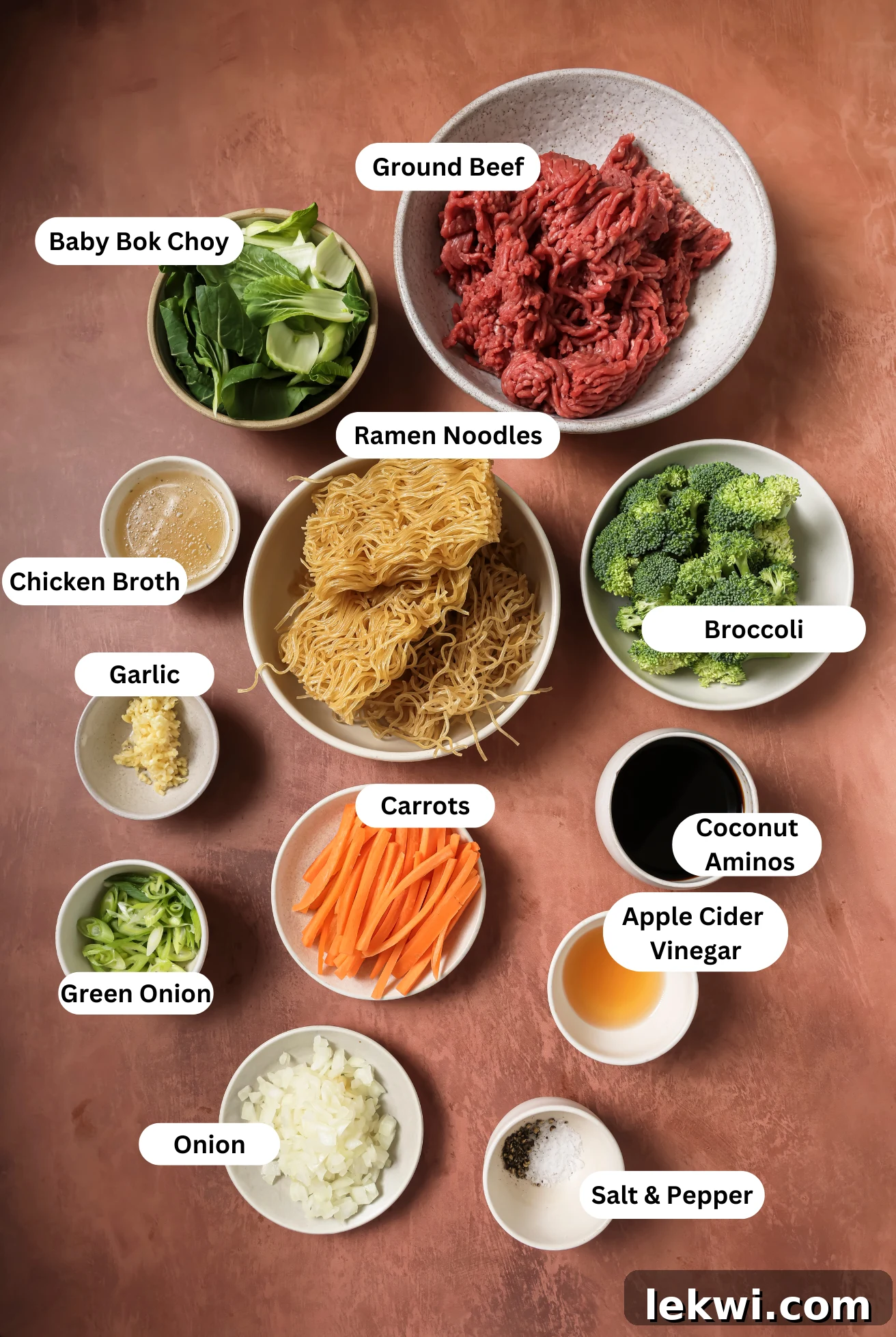 All of the fresh ingredients needed to prepare the ground beef ramen noodle stir fry, laid out on a countertop.