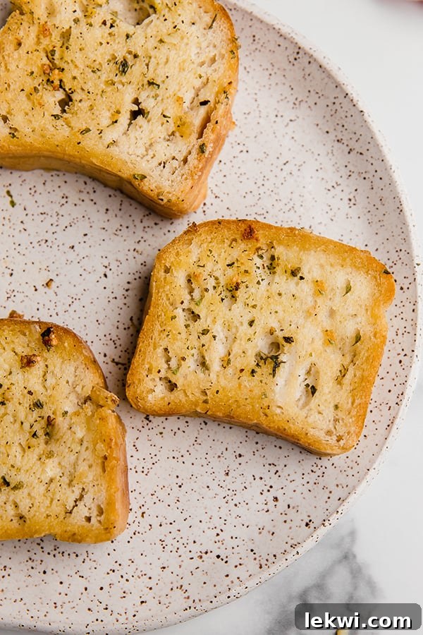 A speckled plate with three slices of golden brown gluten-free Texas toast, perfectly crunchy and ready to eat.