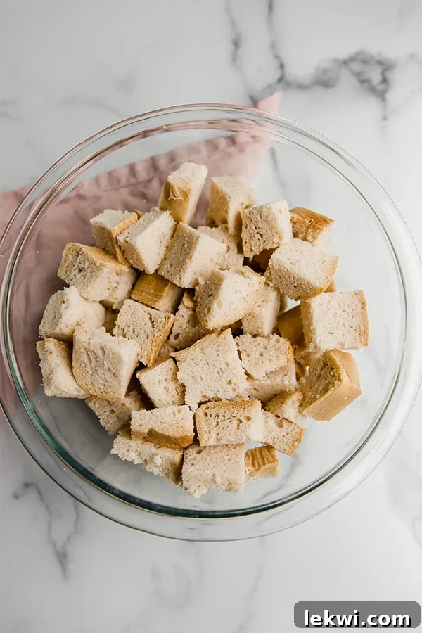 Gluten-free sourdough bread cubes in a large mixing bowl, perfectly cut and ready to be combined with other stuffing ingredients.