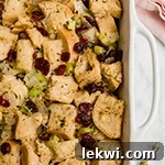A white baking pan filled with golden gluten-free stuffing after baking, ready for serving.