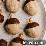 A speckled plate filled with many acorn donut holes.