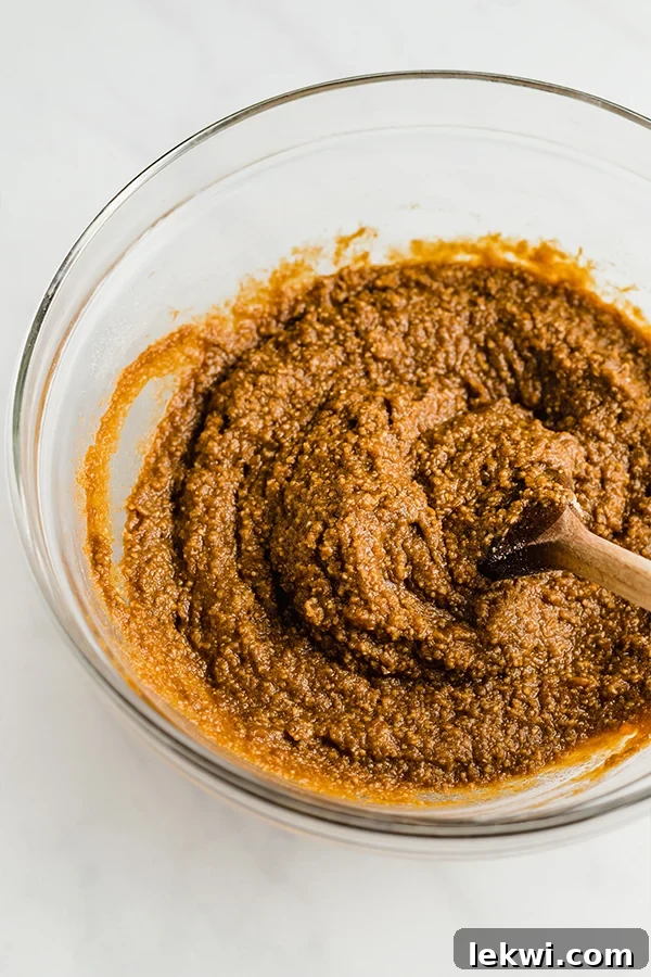 A mixing bowl filled with the combined wet and dry ingredients for sweet potato gingerbread, ready for baking.