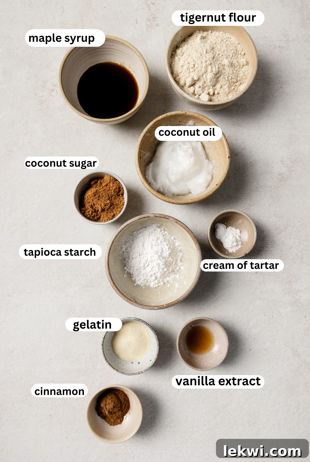 Individual bowls containing the dry ingredients for gluten-free snickerdoodle cookies: tigernut flour, tapioca starch, gelatin, baking soda, and cream of tartar.