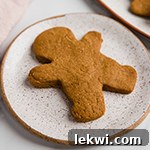 Undecorated gingerbread cookie on a plate.