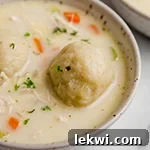 Gluten free chicken and dumplings in a bowl topped with parsley.