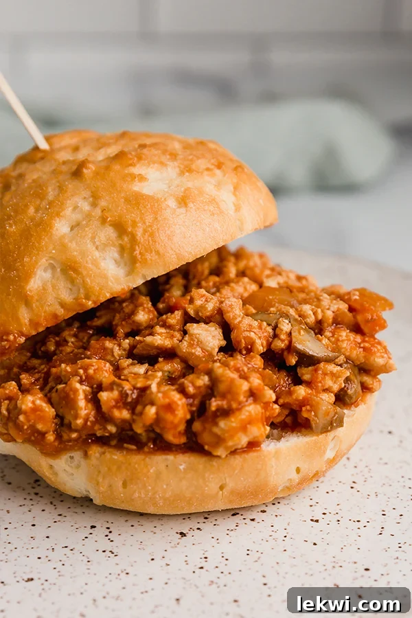 Turkey sloppy joe in a sandwich bun with a toothpick, ready to eat.