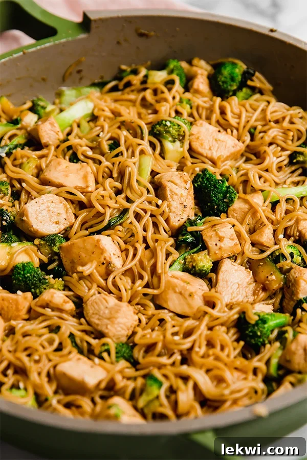 Close-up of a chicken and ramen stir fry in a bowl, showcasing the rich sauce and tender ingredients.