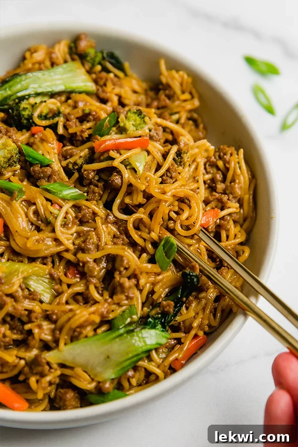 A delicious bowl of Ground Beef Ramen Stir Fry with chopsticks, showcasing tender beef, vibrant vegetables, and gluten-free noodles.