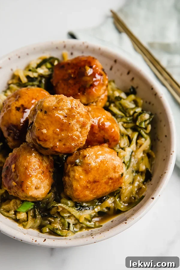 Turkey teriyaki meatballs in a bowl with zucchini noodles, highlighting a healthy and delicious meal.
