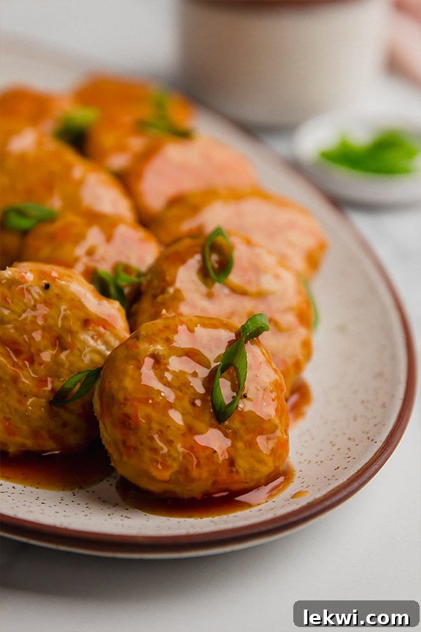 Sweet and sour poppers on a plate garnished with green onions.