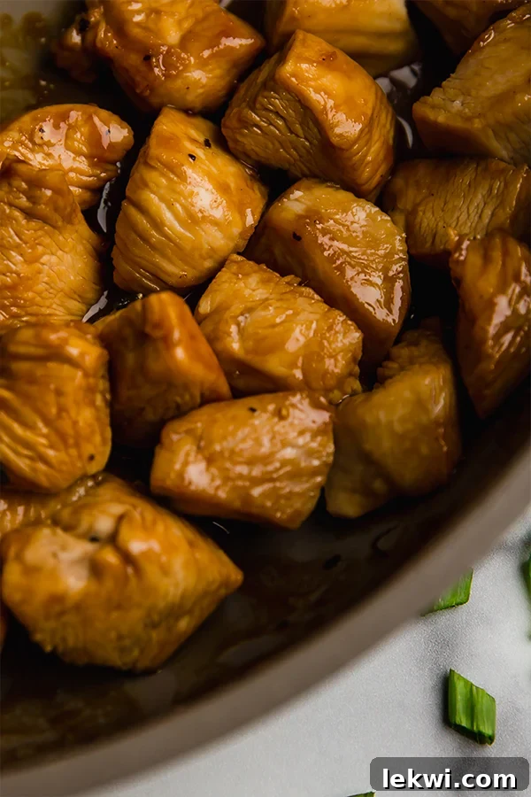 Close-up shot of cooked Thai chicken sizzling in a skillet, showcasing its golden-brown sear and delicious marinade.