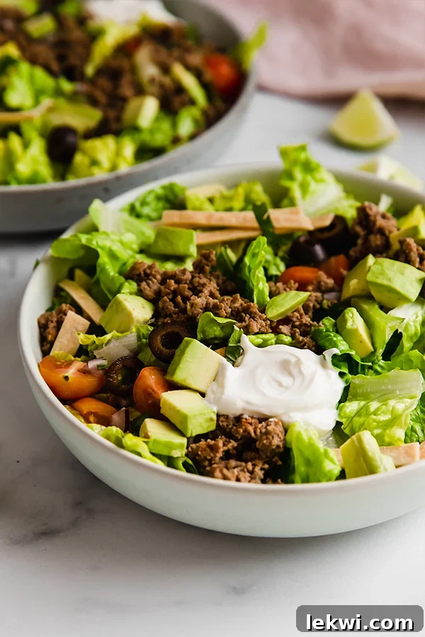 Taco salad with avocado and olives in a bowl.