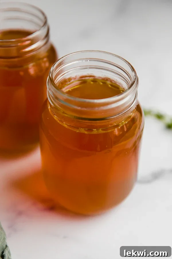 Glass jars of nutrient-rich chicken bone broth, ready for storage and use in various recipes.