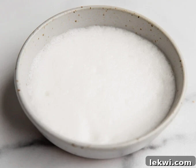 A bowl filled with aquafaba, the liquid from canned chickpeas, ready to be whipped as an egg substitute.