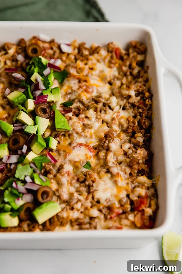 Golden-brown taco cauliflower rice casserole in a baking dish, freshly baked and ready to serve.