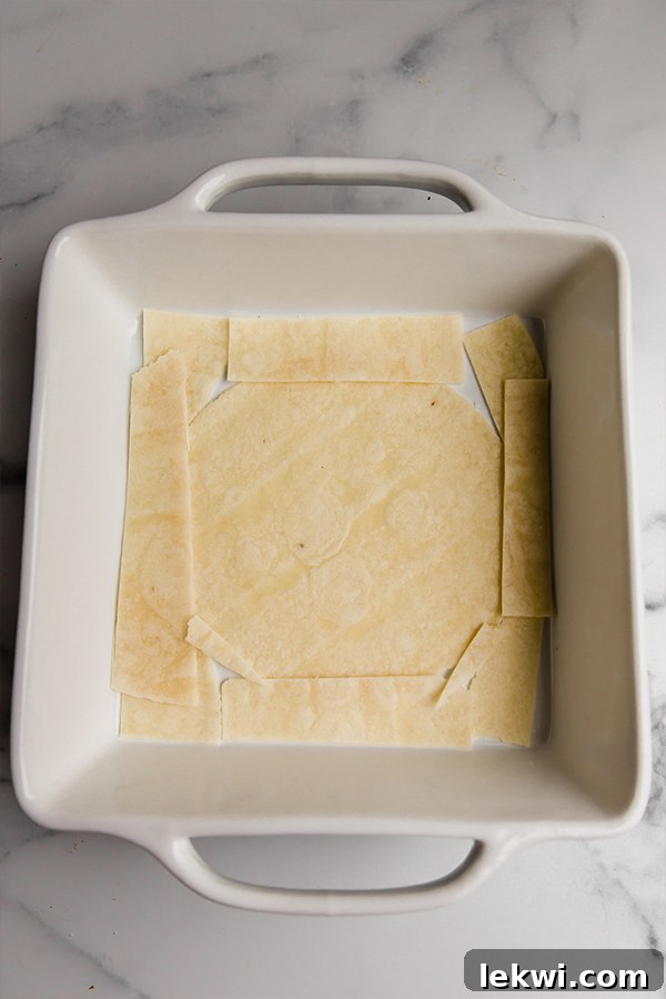 Grain-free tortillas layered in a baking dish, forming the base for the taco casserole.