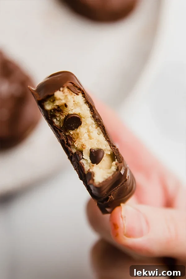 Person holding a chocolate covered cookie dough Easter egg missing a bite.