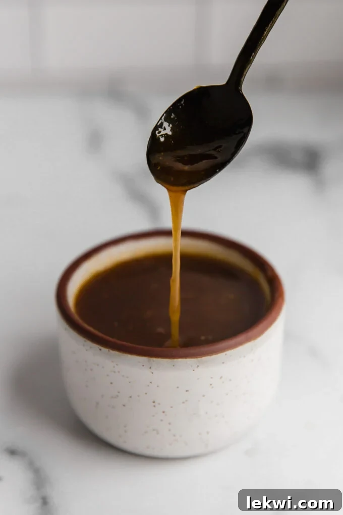 Instant Pot Pork Tenderloin gravy in a small cup with a spoon