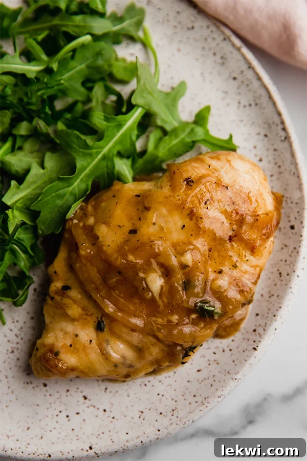 French onion chicken and greens on a plate.
