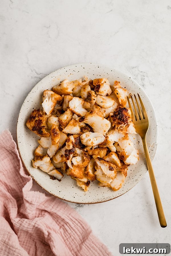 Perfectly seared and seasoned white fish fillets resting on a plate, ready for taco assembly.