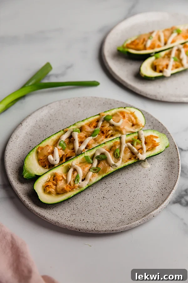 Buffalo chicken stuffed zucchini boats on a plate, ready to be enjoyed.