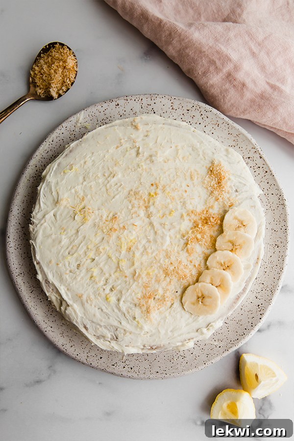 A beautifully frosted coconut flour lemon banana cake with a smooth vanilla topping.