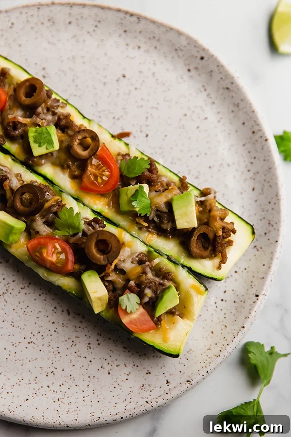 Delicious taco-stuffed zucchini boats arranged neatly on a plate, ready to be served.