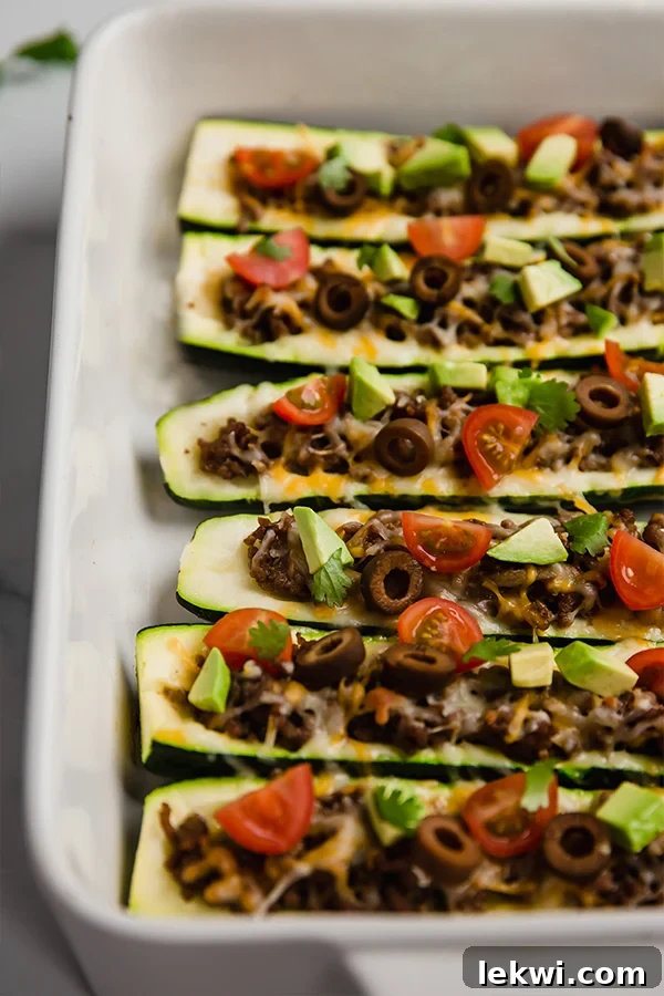 Perfectly baked taco-stuffed zucchinis resting in a baking dish, golden and inviting.