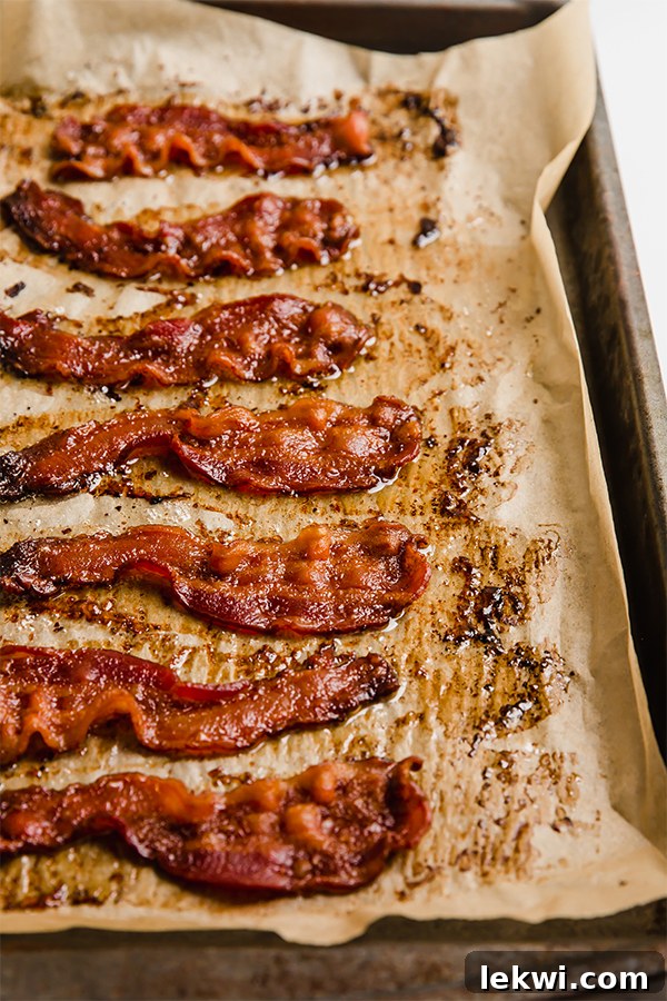 Sheet pan with cooked bacon fresh out of the oven, glistening and golden.