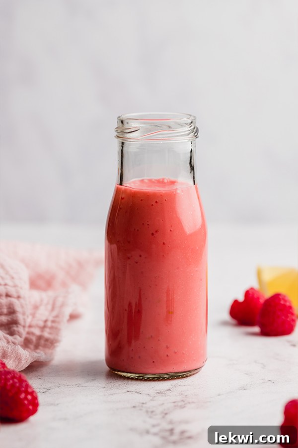 Raspberry vinaigrette dressing in a jar, vibrant and fresh.