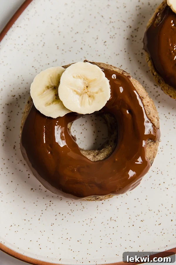Banana slices beautifully arranged on a glazed banana bread donut, showcasing a perfect sweet topping.
