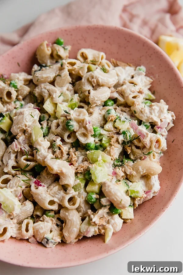 Bowl of tuna pasta salad, showcasing fresh ingredients and a creamy texture.